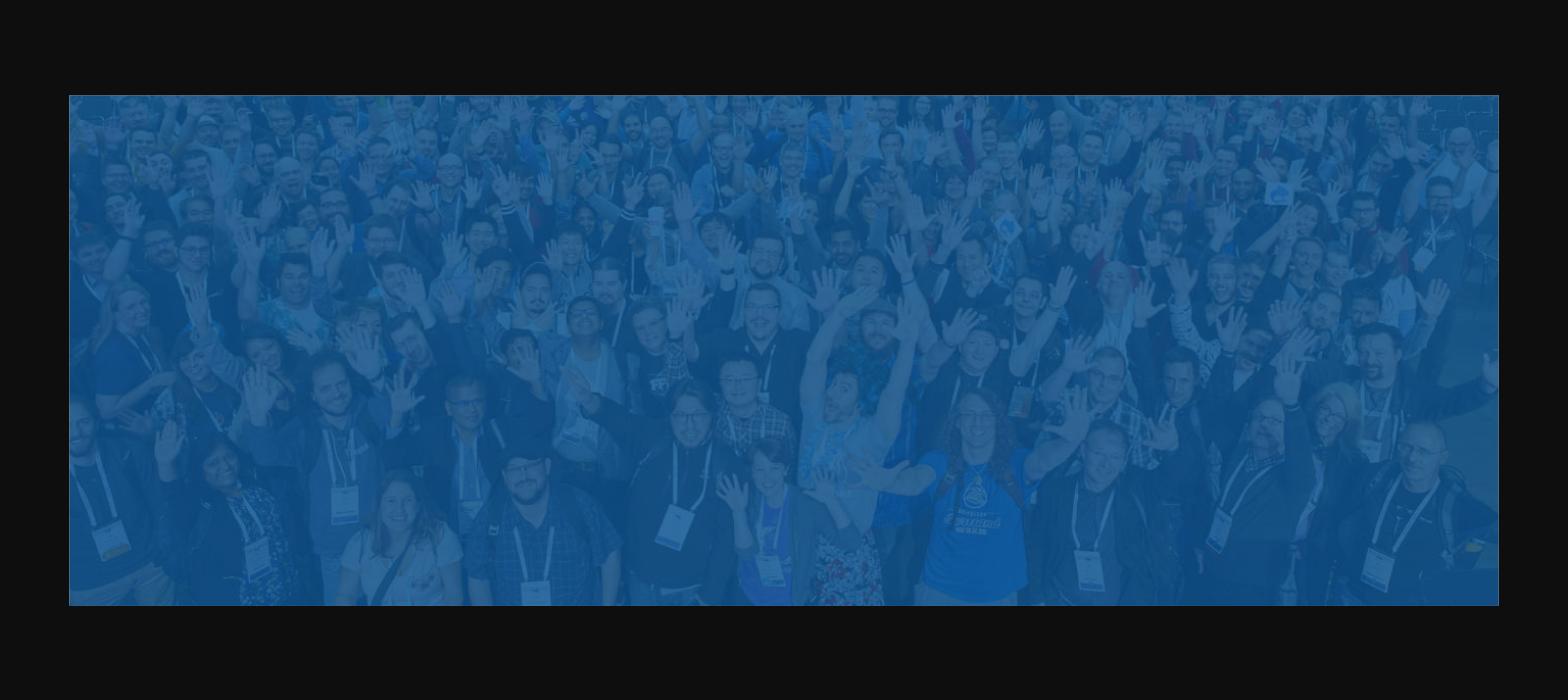 Crowd of Drupal community members raising hands at a conference